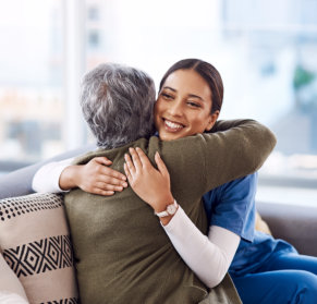caregiver hugging senior woman