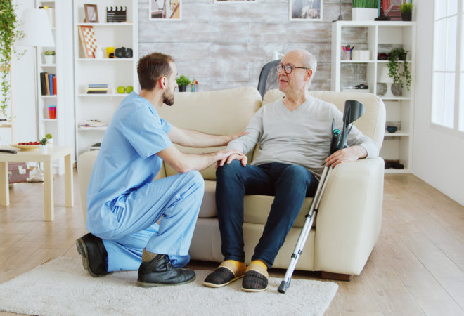 nurse accompanying elder sitting in sofa