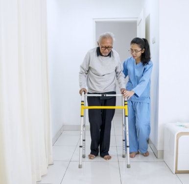 nurse assisting elder in walking
